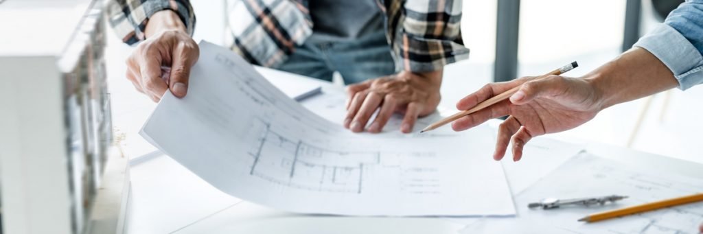 Blog 22 Two people’s hands holding blueprints of a home addition and a pencil in El Paso.
